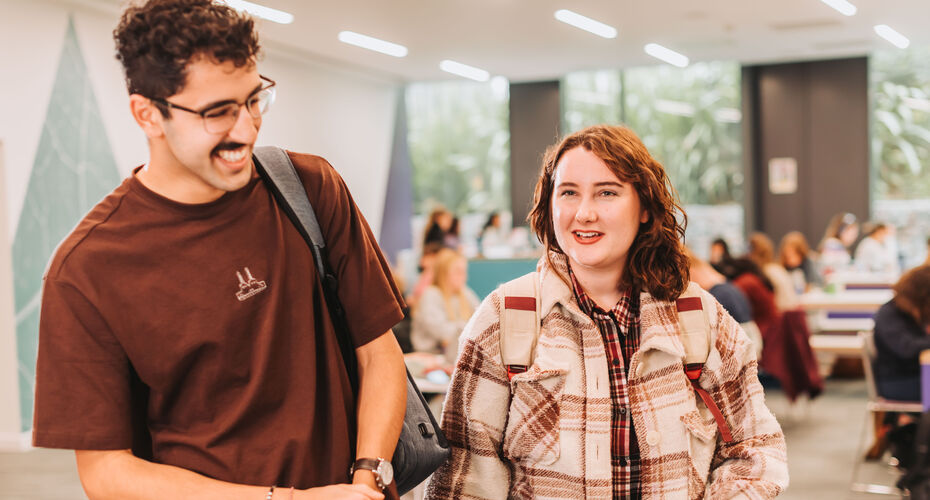 Two students walking indoors