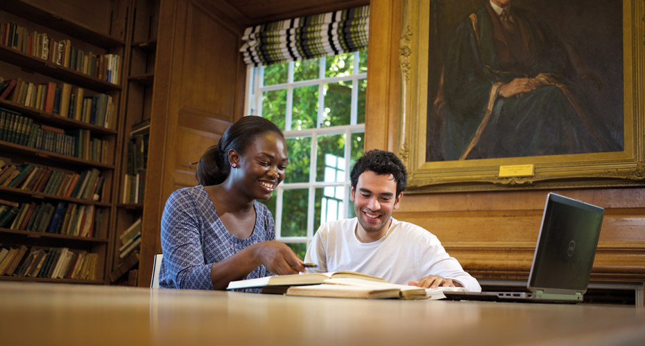 Two students reading a book together