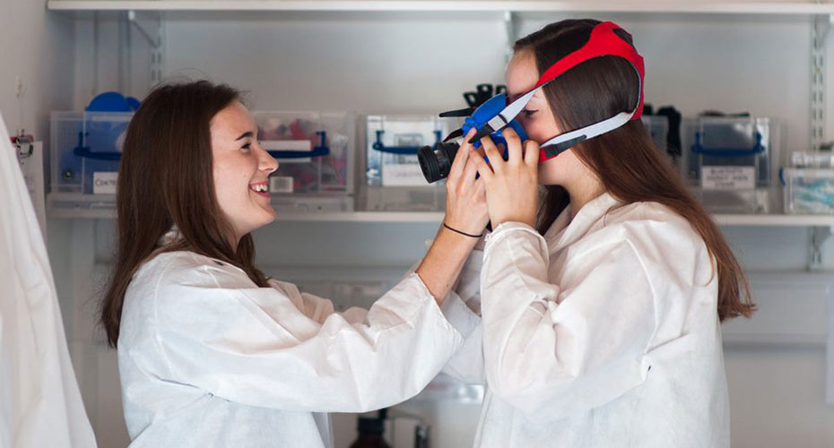 One researcher helps another put on an oxygen monitor mask