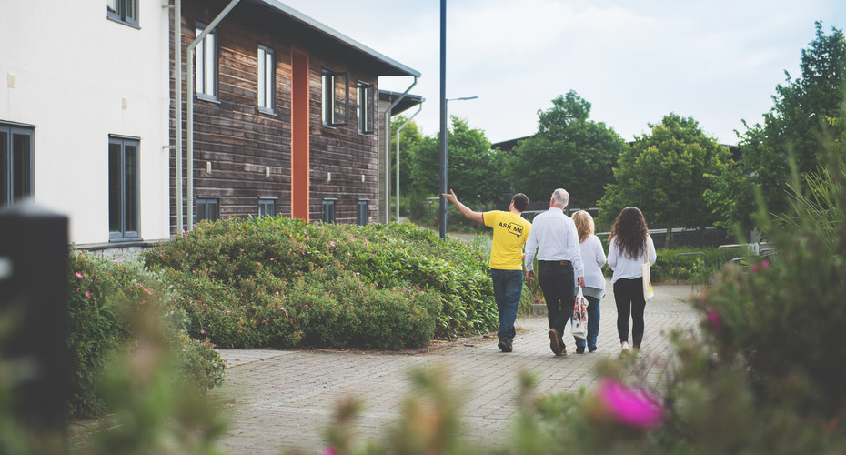 A student volunteer showing a family around penryn's accommodation.