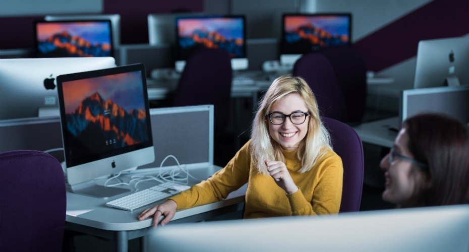 Student in yellow jumper at computer