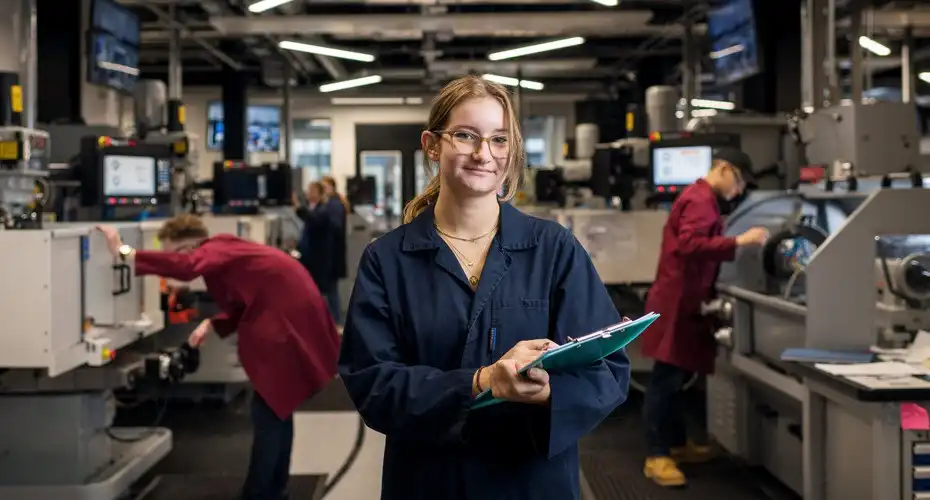 An Engineering PGR student stood in a lab holding a clipboard