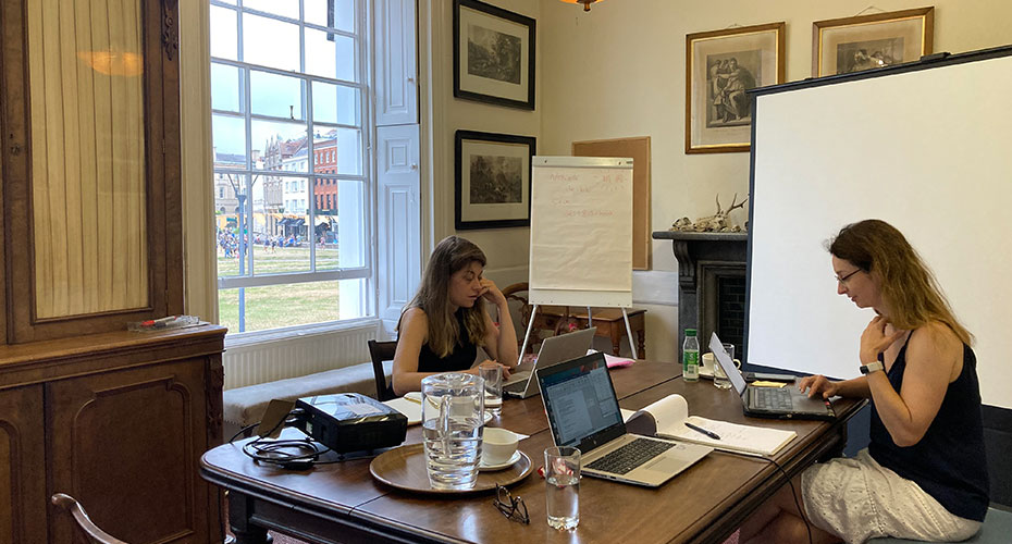 Students writing in a large room overlooking cathedral