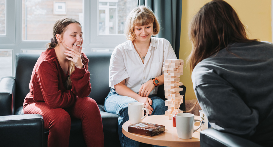 students in communal area playing jenga