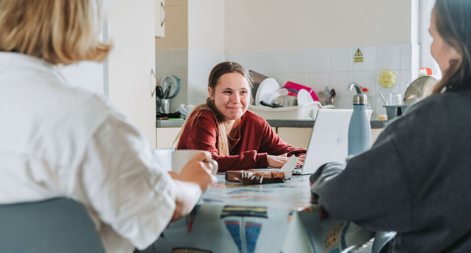 3 students talking at a kitchen table